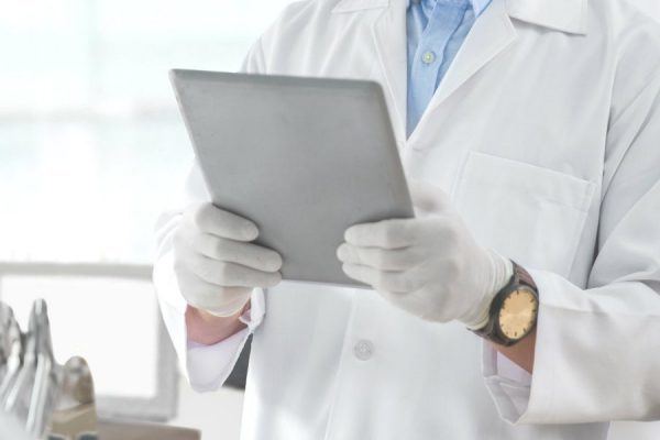 Dentista analisando sua agenda em um tablet