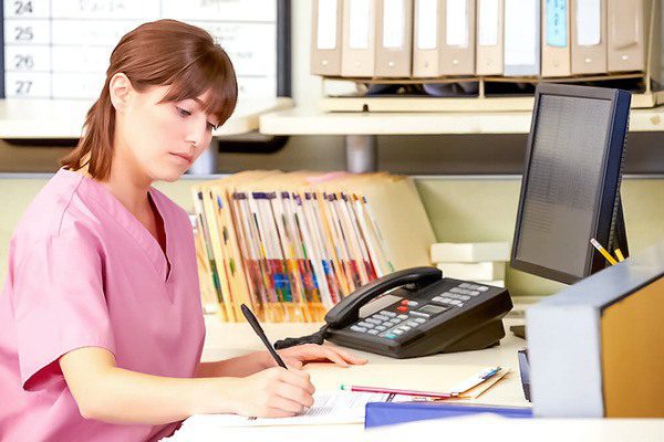 Recepcionista escrevendo em uma folha de papel