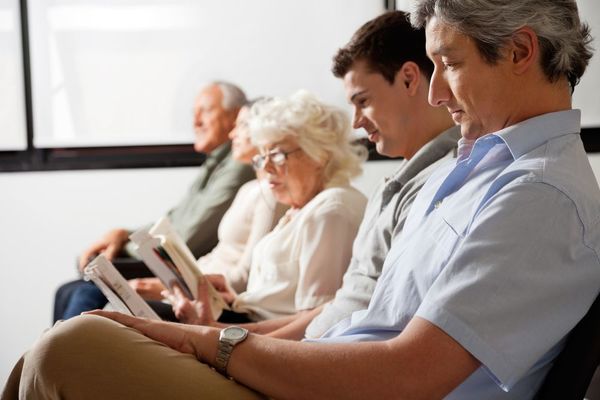 Cinco pacientes lendo e esperando serem chamados pelo dentista